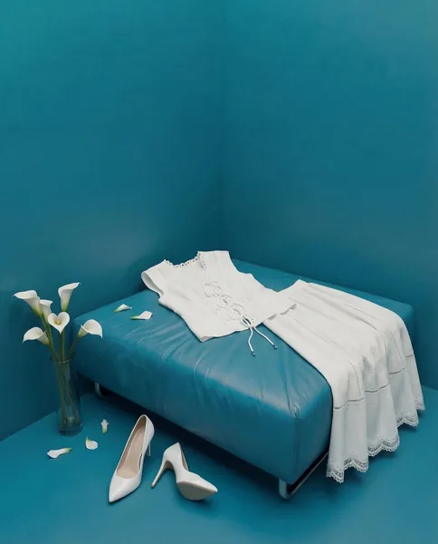 White dress and shoes in a turquoise room. Colour-blocked concept