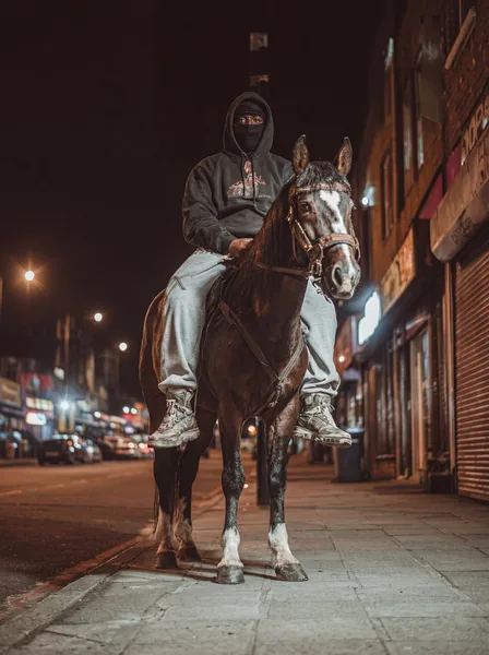 Model on horseback on a night street. Cinematic editorial
